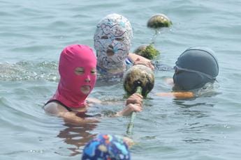 Galleria foto 'Caldo record in Cina, tra i bagnanti spopola il ‘facekini’' - foto 1