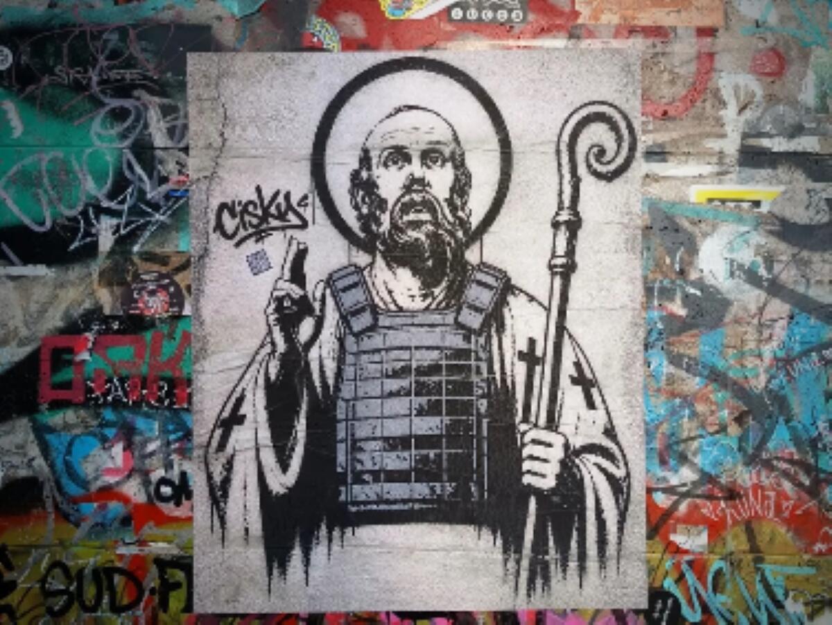 Bari, San Nicola con il giubbotto antiproiettile: la provocazione in una street art dopo l’escaltation criminale Bari, San Nicola con il giubbotto antiproiettile: la provocazione in una street art dopo l’escaltation criminale